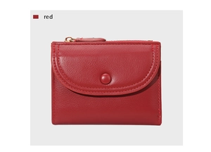 Detalle de cartera de cuero rojo con grano de lichi, cremallera dorada y botón a presión