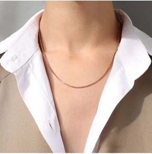 Detail of 1.2mm gold box chain necklace in titanium steel on model with business attire