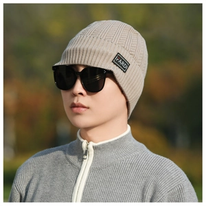 Close-up of khaki knit winter hat with IFARDI label and warm thickened texture