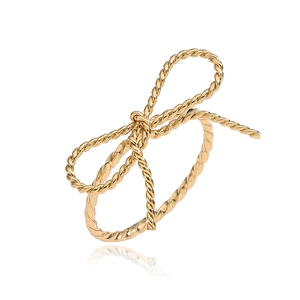 Detailed close-up of a golden bow ring with textured twisted rope band design
