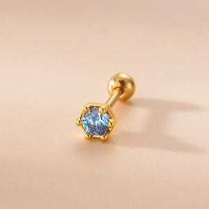 Detalle de pendiente dorado con circonita azul, engaste de seis garras y cierre de rosca