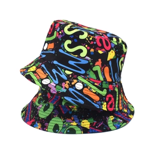 Detail of two reversible bucket hats with vibrant graffiti prints on black fabric
