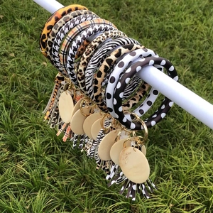 Patterned PU leather bracelet keychains with leopard print and tassels on green grass
