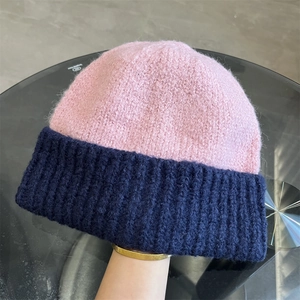 Detail of pink and navy blue color-block knitted beanie showing thick textured wool material