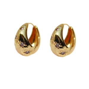 Chunky gold hoop earrings with purple starburst zircon in a polished drop shape