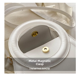 Close-up of golden magnetic clasp and fine white leather texture on fashion handbag