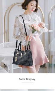 Detail of black geometric pattern handbag with pearl leaf pendant and gold hardware