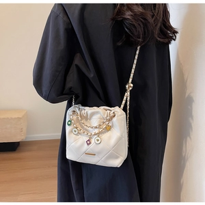 Quilted bucket bag with colorful heart charms on chain strap and gold hardware accents