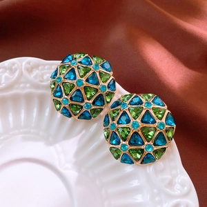 Detailed macro view of vintage geometric diamond earrings with blue and green crystals