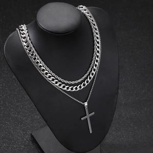 Detailed close-up of triple-layered silver stainless steel necklaces with cross pendant