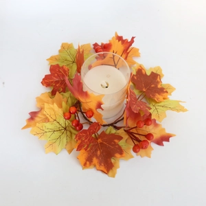 Halloween harvest wreath with maple leaves and berries around a glass candle holder