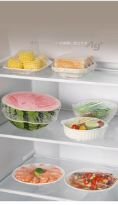 Elastic food covers sealing watermelon and bowls inside a refrigerator to keep freshness