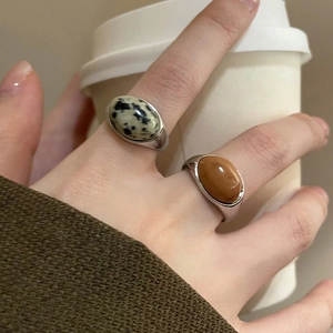 Close-up of retro oval stone open rings in silver with amber and spotted patterns