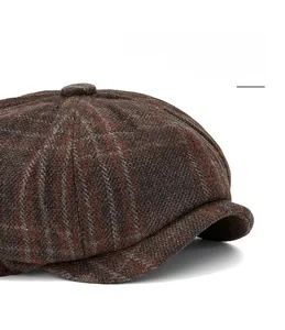 Detail of retro dark brown plaid wool newsboy cap with textured fabric and curved brim