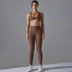 Detail of high-waisted yoga leggings and twist-front sports bra in brown matte fabric