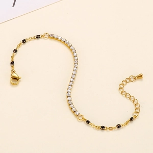 Detail of gold chain bracelet with rhinestones and black enamel beads in S-curve
