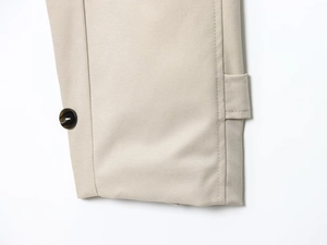 Dettaglio manica trench beige con trama in tessuto twill e cinturino con bottone scuro