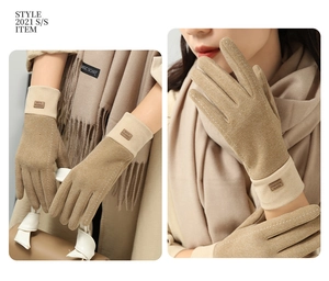 Detail of camel suede winter gloves with ribbed cuffs and white decorative stitching