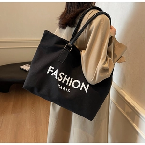 Detailansicht der schwarzen Canvas-Einkaufstasche mit Fashion Paris Aufdruck und Lederriemen