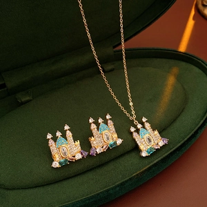 Detailed close-up of a castle-shaped gold necklace and earring set with colorful zircons