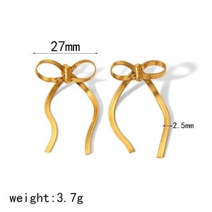 Detail of 18K gold bow earrings with dimensions 27mm width and snake chain texture