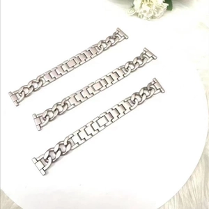 Detailed view of silver denim chain watch strap for smartwatches on a white surface