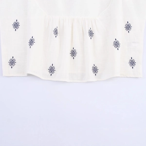 Bohemian retro white linen shirt featuring navy blue ethnic embroidery and pleated details