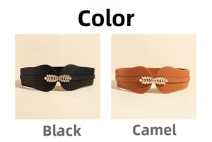 Detail view of elastic waist belts in black and camel with gold leaf shaped metal buckles