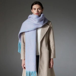 Long light purple boucle yarn scarf with light blue fringe on a model in a beige coat