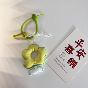 Detail of yellow flower plush keychain with white cloud charm and green spiral cord