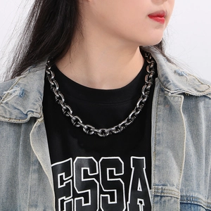 Close-up of men's chunky titanium steel rock chain necklace worn by a model in dark grey