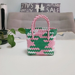 Detail shot of the pink and green woven texture and zigzag edges of this basket bag