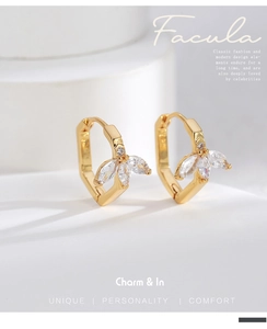 Macro detail of gold plated leaf earrings with marquise cut white zircon stones