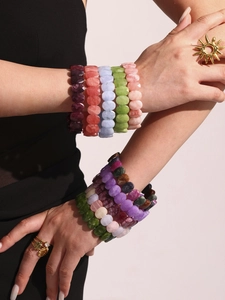Détail de bracelets colorés en pierres naturelles facettées portés en superposition