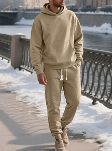 Close-up of khaki jacquard knit men's tracksuit featuring a drawstring hoodie and textured fabric