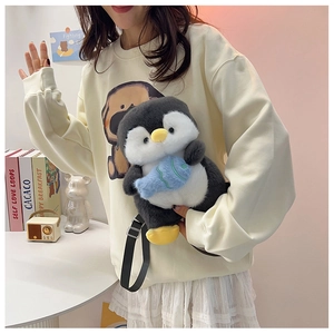 Cute plush penguin backpack with blue fish accessory shown worn by a model in daily life