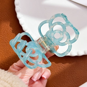 Translucent light blue hollow camellia acetate hair claw clip with subtle glitter