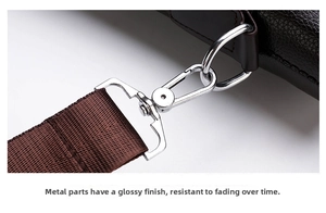 Detail of silver metal hook and D-ring on dark brown textured leather briefcase