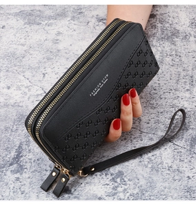 Detail of black double zipper long wallet with embossed texture and hand strap
