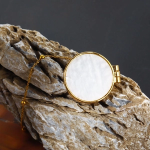 Vintage golden sun necklace with white mother of pearl locket pendant on rock base