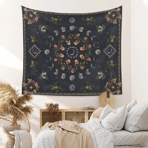 Detail of bohemian tapestry featuring moon phases and floral patterns on a bedroom wall