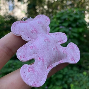 Close-up of pink embossed leather bear keychain with premium textured stitching detail