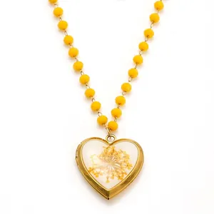 Collier médaillon cœur doré avec fleurs séchées jaunes et chaîne à perles assortie