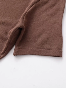 Détail en gros plan du t-shirt asymétrique marron en maille fine avec coutures visibles