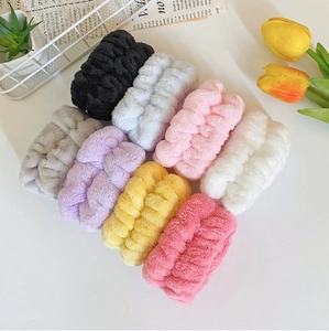 Flat lay of colorful coral fleece yoga headbands and wristbands on a textured tabletop