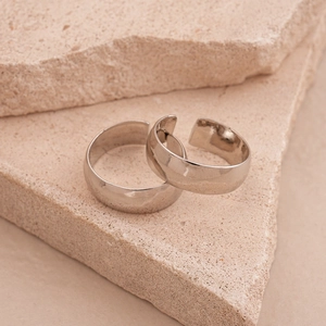 Macro detail of wide metallic rings on textured stone background for a minimalist style