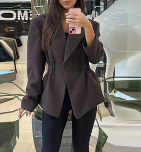 Détails d'un blazer marron foncé cintré avec boutons à boutonnage simple et coupe ajustée chic
