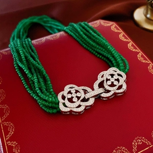 Detailed view of multilayer green beaded necklace with sparkling floral zircon clasp