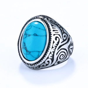 Detailed side view of vintage silver ring with engraved floral patterns and blue turquoise