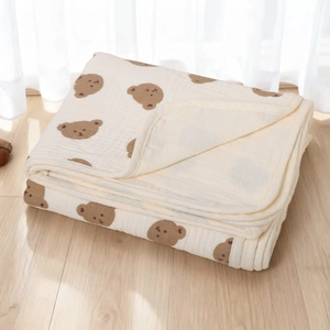 Soft multi-layer cotton baby blanket with cute brown bear prints on a cream background